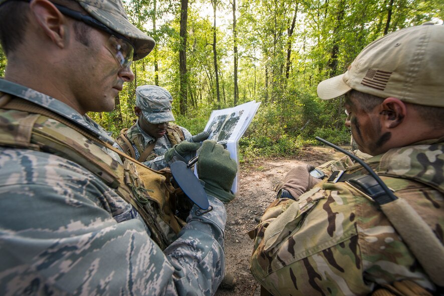 U.S. Air Force Capt. William Theisner, left, 41st Rescue Squadron (RQS) HH-60G Pave Hawk pilot, and Tech. Sgt. Vincent Hnat, 41st RQS special missions aviator, study a map during combat survival training at Moody Air Force Base, Ga., April 8, 2014. To complete training, Airmen must navigate to four different GPS locations and maintain communication with friendly forces while avoiding detection by opposing forces. (U.S. Air Force photo by Airman 1st Class Ryan Callaghan/Released)
