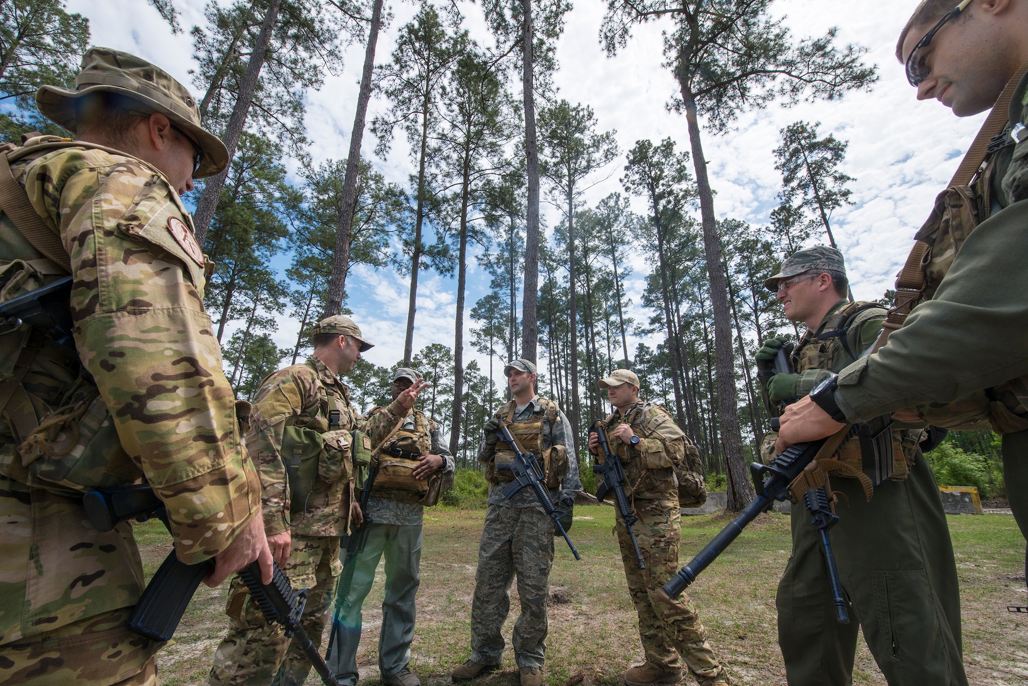 Airmen participating in combat survival training gather around U.S. Air Force Staff Sgt. Daniel Wiggins, 347th Operations Support Squadron NCO in charge of survival, evasion, resistance and escape operations and training, for an explanation of training events at Moody Air Force Base, Ga., April 8, 2014. Aircrew members learned how to survive in isolation and evade enemy forces in the event they are involved in an aircraft accident, and they are required to recomplete the training every three years. (U.S. Air Force photo by Airman 1st Class Ryan Callaghan/Released)