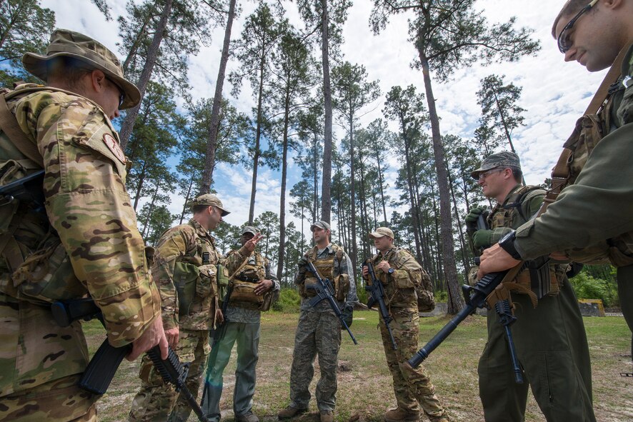 Airmen participating in combat survival training gather around U.S. Air Force Staff Sgt. Daniel Wiggins, 347th Operations Support Squadron NCO in charge of survival, evasion, resistance and escape operations and training, for an explanation of training events at Moody Air Force Base, Ga., April 8, 2014. Aircrew members learned how to survive in isolation and evade enemy forces in the event they are involved in an aircraft accident, and they are required to recomplete the training every three years. (U.S. Air Force photo by Airman 1st Class Ryan Callaghan/Released)