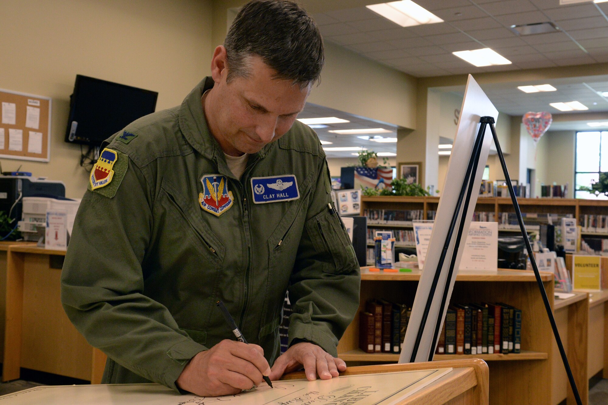 U.S. Air Force Col. Clay Hall, 20th Fighter Wing commander, signs a declaration for the right to libraries at the W.A. McElveen Information Learning Center, Shaw Air Force Base, S.C., April 14, 2014. The McElveen ILC serves military communities, and colleges by providing a wide variety of online mission essential, educational and self-improvement resources; college level examination programs, defense activity for non-traditional education support, and printed books,  CD and digital audio books, music, foreign language material, video games, movies, Tumble e-books for children, and more. (U.S. Air Force photo by Airman 1st Class Jonathan Bass/Released)