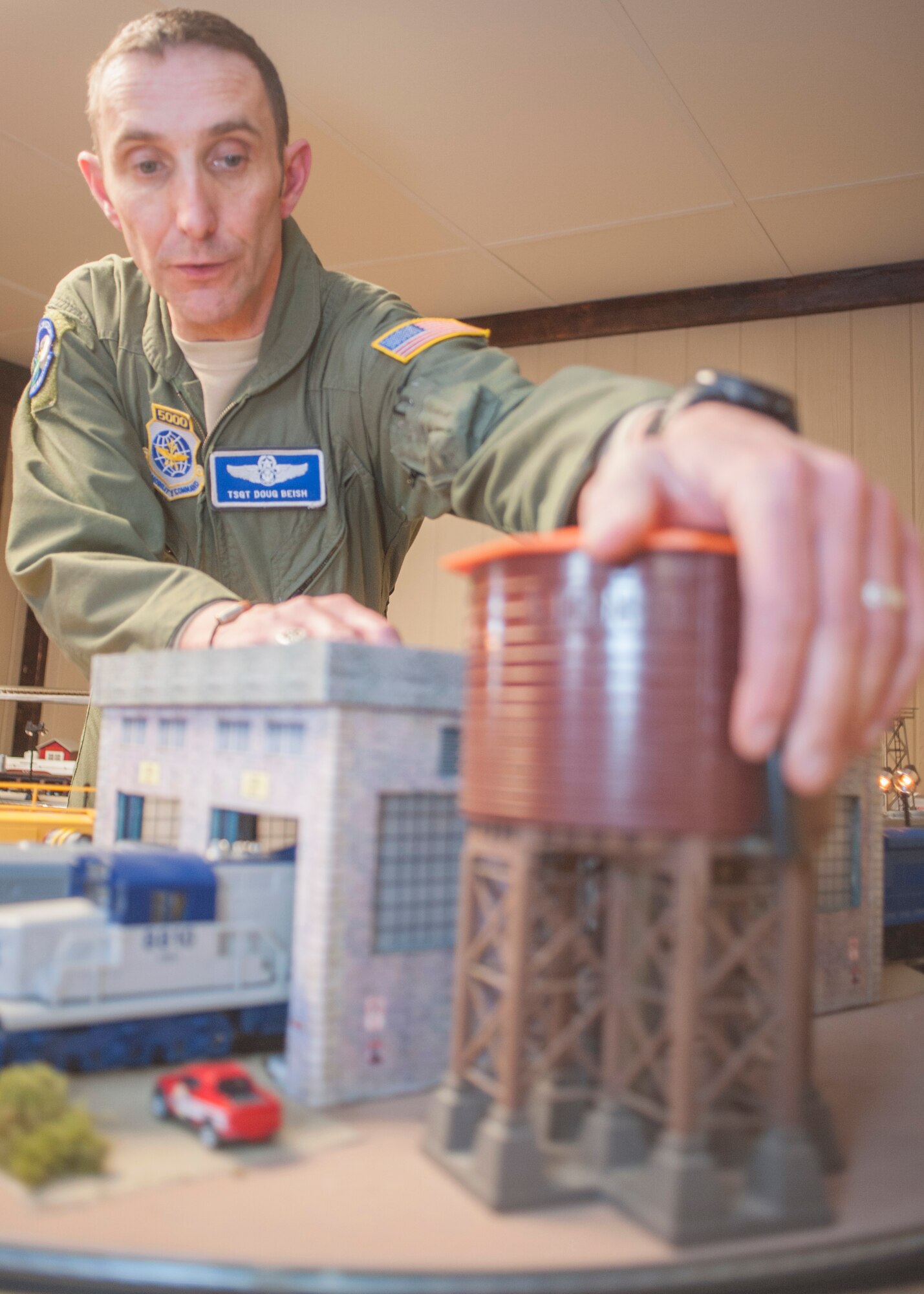 Tech. Sgt. Doug Beish, 436th Operations Support Squadron C-5M Super Galaxy loadmaster trainer, repositions a model water tower while running his model trains April 9, 2014, at his parents’ home in Dover, Del. Beish is retiring after 20 years of military service in the Air Force and will soon start his dream job of becoming a train conductor. (U.S. Air Force photo/Senior Airman Jared Duhon)