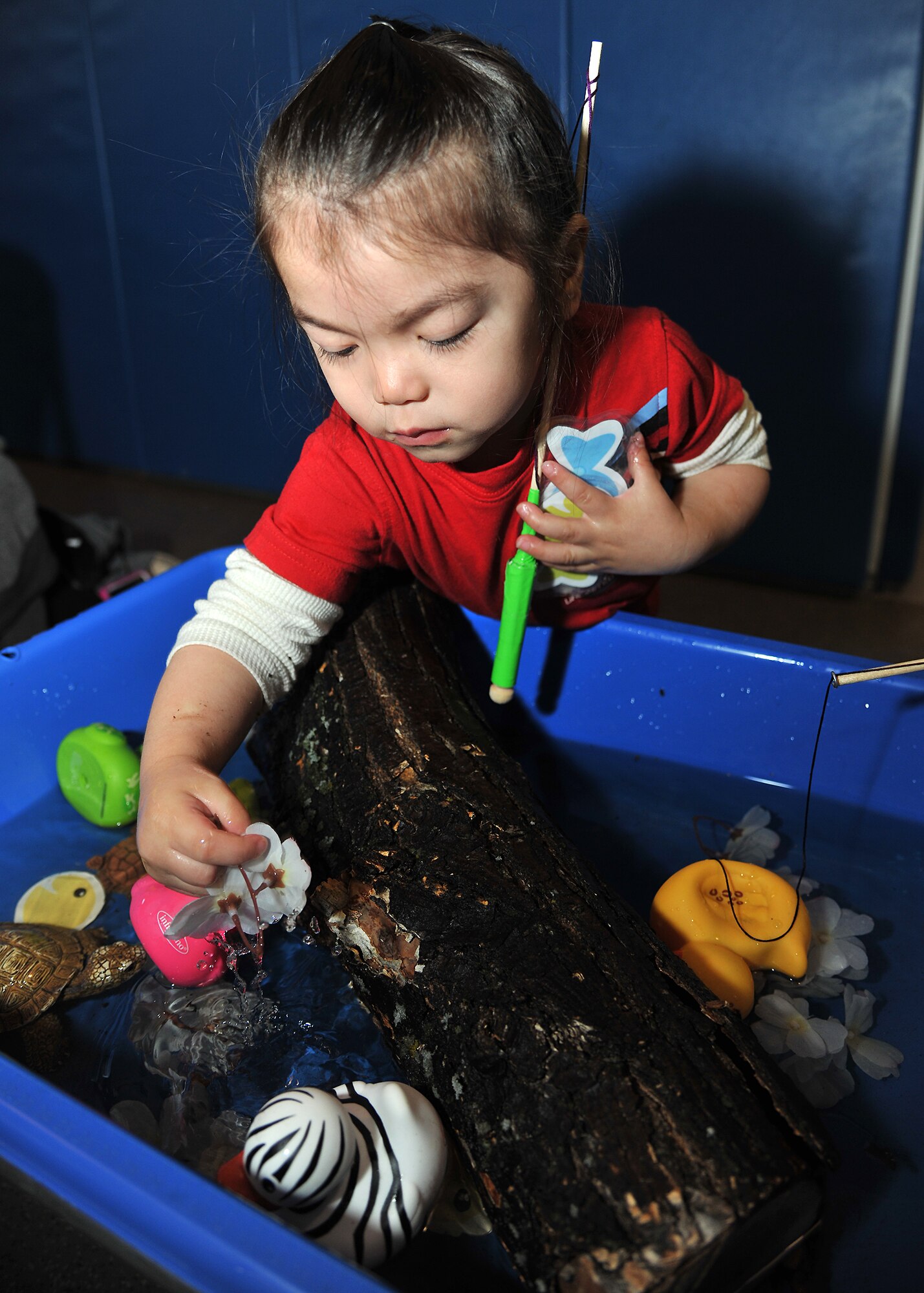 Raiden Fegurgor, 2, picks up a flower at a water sensory activity on April 9, 2014 at Liberty Square during the Beautiful Child Photo Shoot and Activity Fair on Grand Forks Air Force Base, N.D. Different activities were set up to celebrate Month of the Military Child as well as Child Abuse Prevention Month, which are observed in April. (U.S. Air Force photo/Senior Airman Xavier Navarro)