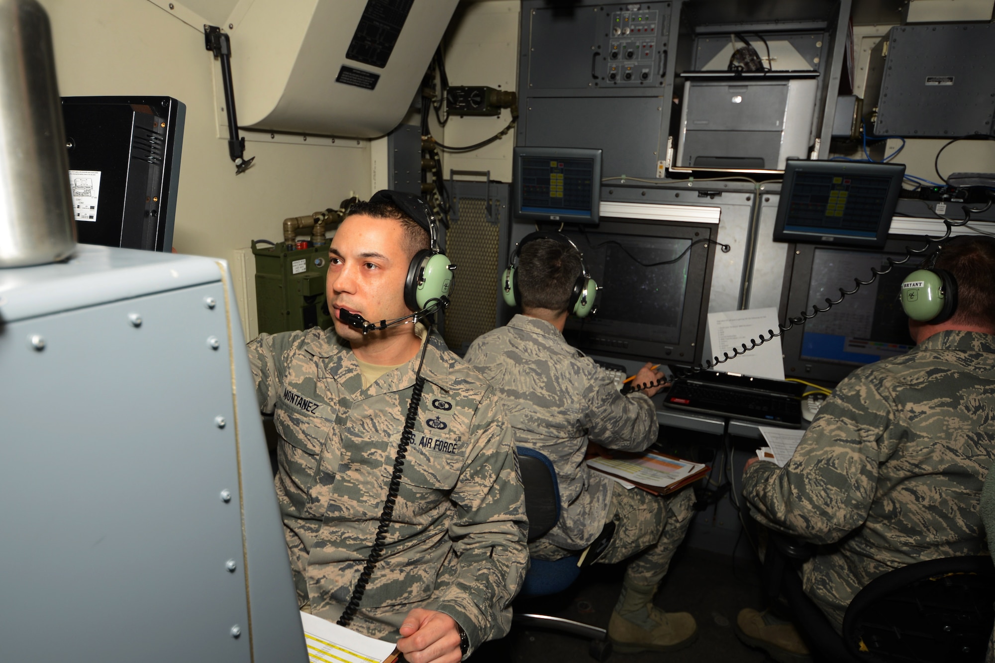 Tech. Sgt. Manny Montanez, weapons director with the 103rd Air Control Squadron, coordinates with air traffic during a training exercise at the Orange Air National Guard Station, Orange, Conn., April 5, 2014. Montanez works inside one of the operations modules there as he communicates with pilots during the exercise. (U.S. Air National Guard photo by Senior Airman Jennifer Pierce)