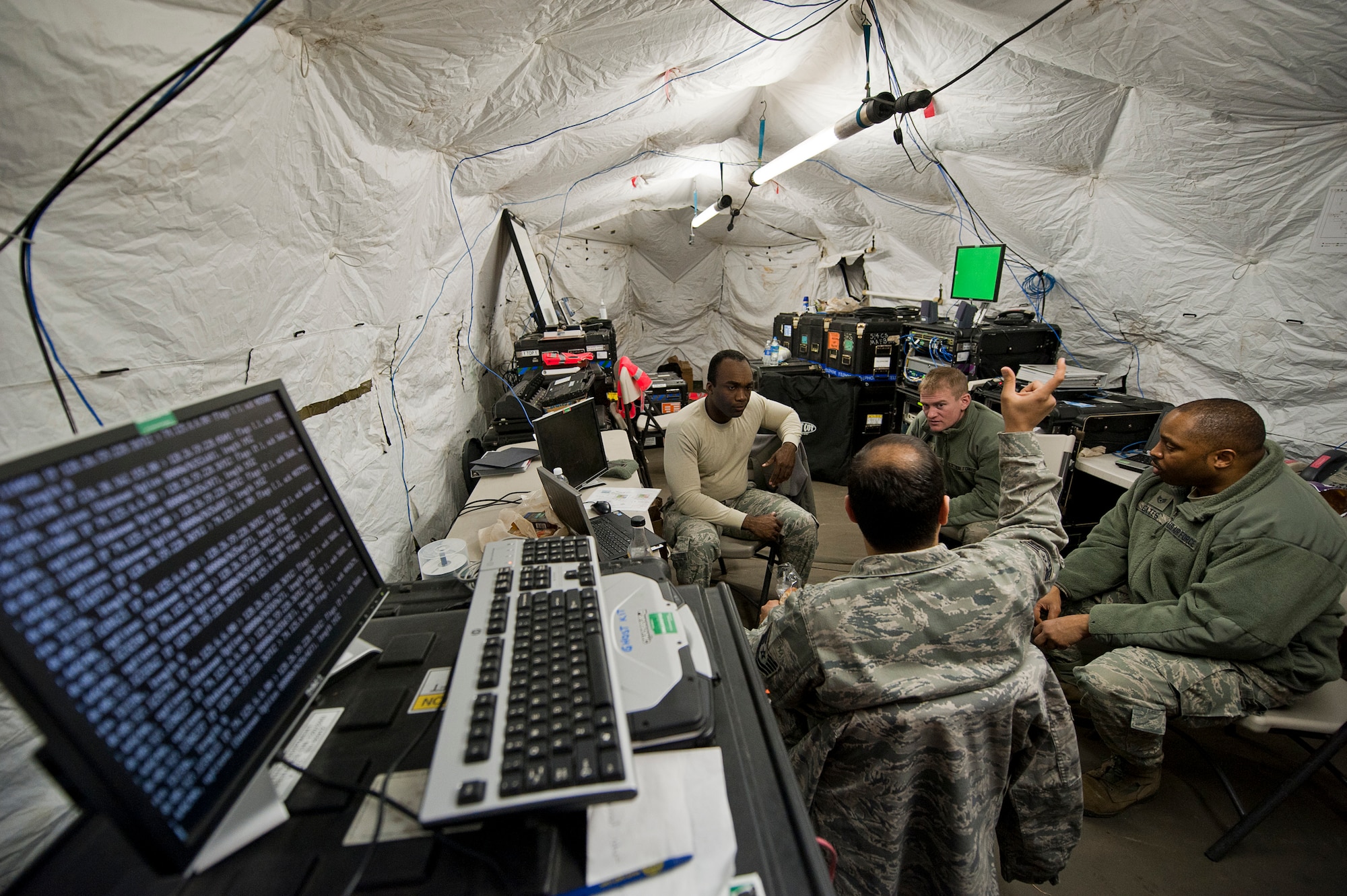 (From right counter clockwise) Staff Sgt. Michael Gates, Senior Airman Justin Walsh, Senior Airman Sheldon Spence and Tech. Sgt. Kasin Mothana with the 42nd Combat Communications Squadron, discuss hypothetical communication situations during Operation Global Medic, Joint Base McGuire-Dix-Lakehurst, N.J., March 1.  Global Medic is a world-class joint collective training event that develops and tests a participating unit's airmen collective ability to exercise and evaluate their skills in a rigorous, realistic, joint training environment, which incorporates scenarios that employ the full range of medical functions and situations.  Citizen Airmen from the 42nd CBCS, the 514th Aeromedical Evacuation Squadron and the 514th Aeromedical Staging Squadron participated in the exercise.  (U.S. Air Force photo by Christian Deluca)