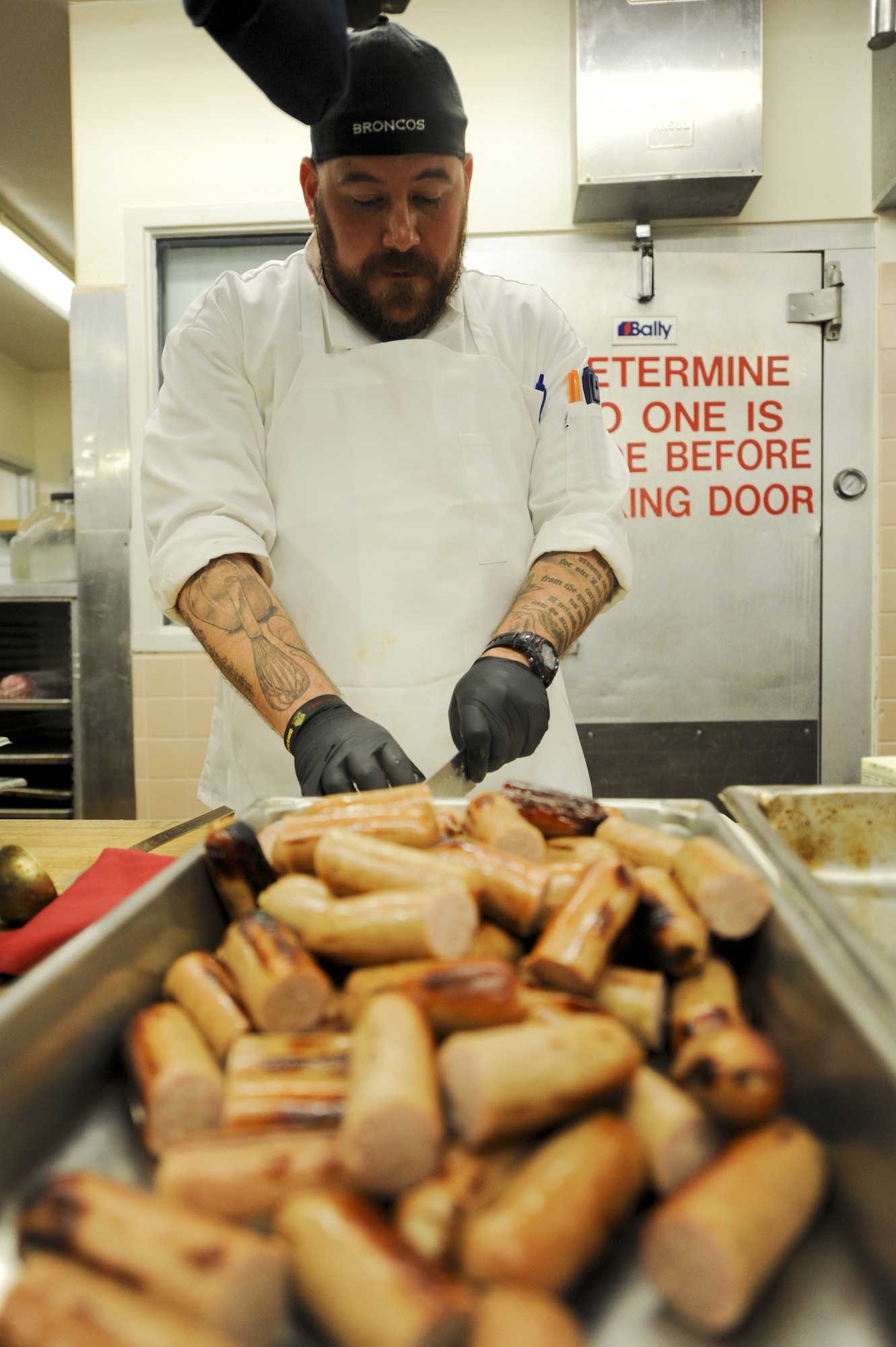 PETERSON AIR FORCE BASE, Colo. – Kirkland Dunning, 21st Force Support Squadron Peterson Club sous-chef, prepares bratwursts April 2. The new team of chefs at the Peterson Club prepared ballpark-themed food for an opening day baseball-themed lunch. (U.S. Air Force photo/Staff Sgt. Jacob Morgan)