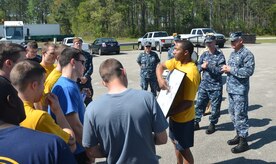 Commander Charles Phillip, Naval Munitions Command commanding officer (right), and Master Chief Petty Officer Jason Roach, NMC command master chief, look on as NMC Sailors are briefed on the route they will be running for the command’s Sexual Assault Awareness Month 5K run April 10, 2014, at Joint Base Charleston – Weapons Station, S.C.  The command event was organized to help raise awareness of the issue of sexual assault. (U.S. Air Force photo/Eric Sesit)