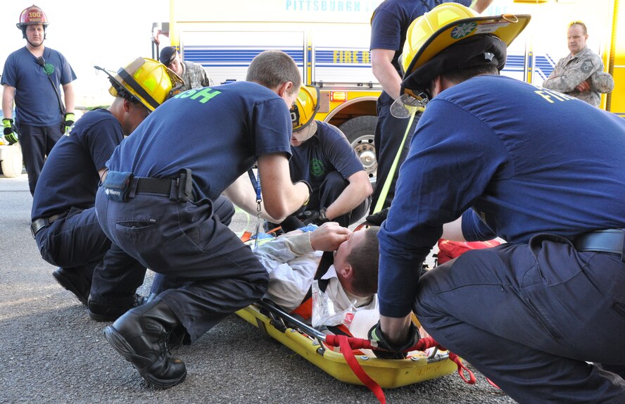 Civilian emergency responders of Allegheny County Airport Authority Fire Rescue release Tech. Sgt. Derek Reynolds, fuel technician with the 911th Maintenance Group, at the end of an extraction exercise at the Pittsburgh International Airport Air Reserve Station, April 10, 2014. The exercise was successfully terminated within 20 minutes of its start thanks to the cooperation between Airmen and emergency responders as well as the quick response of the ACAAF. (U.S. Air Force photo by Senior Airman Marjorie A. Bowlden)