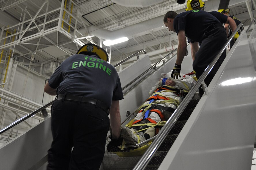 Civilian emergency responders of Allegheny County Airport Authority Fire Rescue carefully move Tech. Sgt. Derek Reynolds, a fuel technician with the 911th Maintenance Squadron acting as the victim in an extraction exercise, from the wings of a C-130 Hercules at the Pittsburgh International Air Reserve Station, April 10, 2014. The emergency responders arrived at the hangar within seven minutes of the start of the exercise and took over the scene six minutes thereafter. (U.S. Air Force photo by Senior Airman Marjorie A. Bowlden)