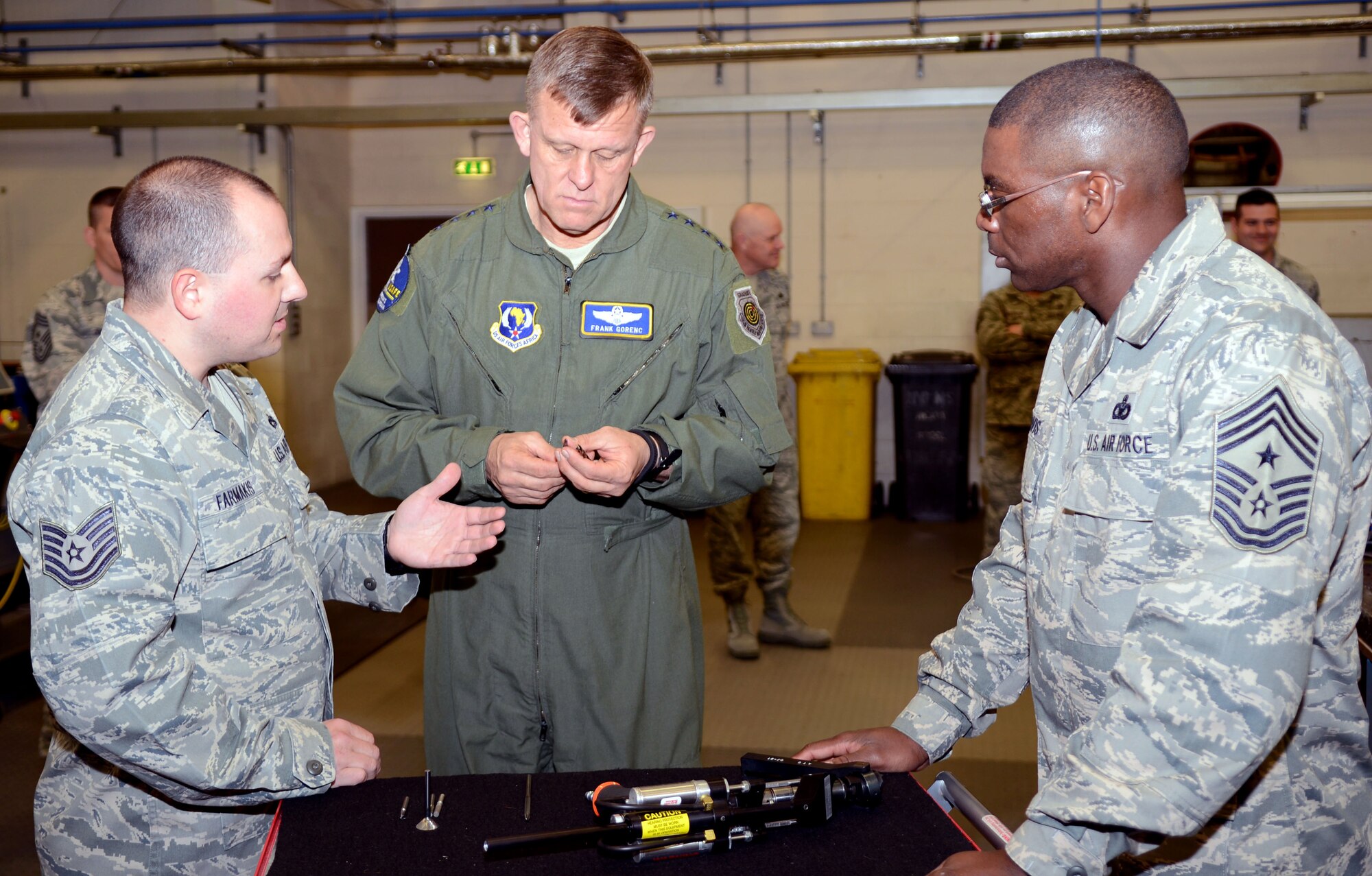 U.S. Air Force Tech. Sgt. Timothy Farmakis, 100th Maintenance Squadron Corrosion NCOIC from Las Vegas, explains the operations of the advance composite pneumatic drill to U.S. Air Force Gen. Frank Gorenc, U.S. Air Forces in Europe  and Air Forces Africa commander, and Chief Master Sgt. James E. Davis, USAFE-AFAFRICA command chief, April 14, 2014, on RAF Mildenhall, England. The maintenance squadron repairs four different airframes: the CV-22 Osprey, KC-135 Stratotanker, MC-130 Combat Talon and the RC-135 Rivet Joint. (U.S. Air Force photo by Airman 1st Class Jonathan Light/Released) 