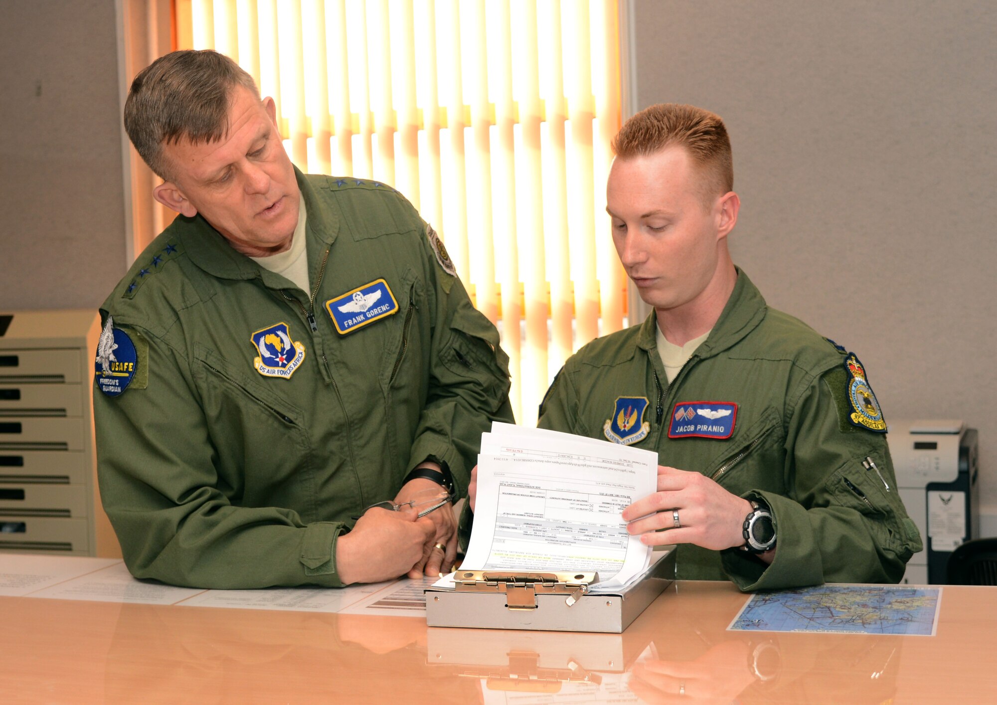 U.S. Air Force Gen. Frank Gorenc, U.S. Air Forces in Europe and Air Forces Africa commander, left, receives a briefing by U.S. Air Force Capt. Jacob Piranio, 351st Air Refueling Squadron KC-135 Stratotanker pilot from Spring, Texas, April 14, 2014, at Bldg. 809 on RAF Mildenhall, England. Piranio discussed the preflight checks the air crew conduct before flying. During his visit, Gorenc toured RAF Mildenhall and stopped by individual squadrons to see the different ways Team Mildenhall Airmen get the mission done. (U.S. Air Force photo by Airman 1st Class Kelsey Waters/Released)