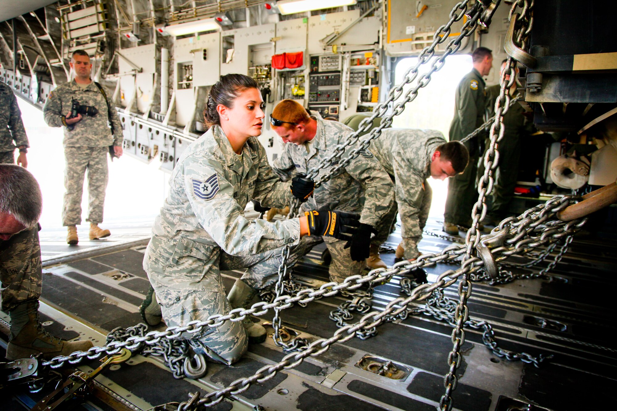 Tech. Sgt. Catherine Desilles, an air transportation specialist with the 38th Aerial Port Squadron at Joint Base Charleston, S.C., grabs hold of a tie down chain as she and her team secure an M1A1SA Abrams main battle tank to the floor of a C-17 Globemaster III Thursday at Wright Army Airfield, Ga. C-17's from JB Charleston, S.C., and Wright-Patterson Air Force Base, Ohio, transported four tanks from Wright AAF to McEntire Air National Guard Base, S.C., in support of a tank movement for the 1/118th CAB. (U.S. Air Force photo by Staff Sgt. Rashard Coaxum/released)