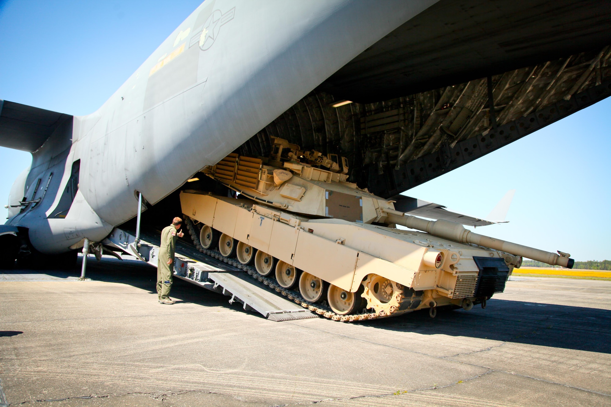 Tech Sgt. Vinnie White, a loadmaster with the 315th Airlift Control Flight, gives the thumbs up to crew members inside the C-17 Globemaster III to continue the onload of the M1A1SA Abrams main battle tank Thursday at Wright Army Airfield, Ga. C-17's from JB Charleston, S.C., and Wright-Patterson Air Force Base, Ohio, transported four tanks from Wright AAF to McEntire Air National Guard Base, S.C., in support of a tank movement for the 1/118th CAB. (U.S. Air Force photo by Staff Sgt. Rashard Coaxum/released)