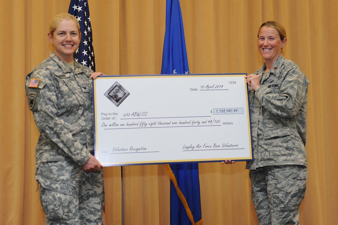 U.S. Air Force Maj. Carrie Wentzel, acting 633rd Force Support Squadron commander, presents a check to U.S. Army Col. Jayne Jansen, 633rd Air Base Wing vice commander, during the Joint Base Langley- Eustis Volunteer Salute at Langley Air Force Base, Va., April 10, 2014. Volunteers saved JBLE more than $1.1 million in 2013. Outstanding Volunteer Certificates and Excellence Awards were also presented during the Volunteer Salute. (U.S. Air Force photo by Senior Airman Brittany Paerschke-O’Brien/Released)