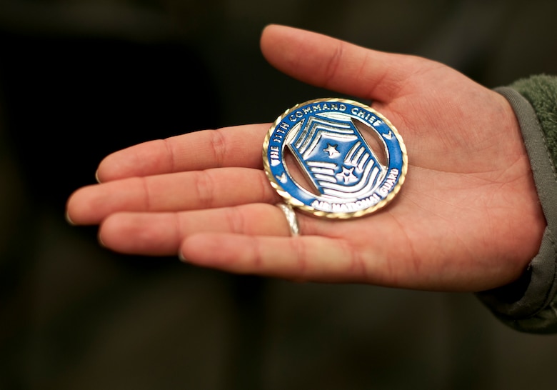 Airmen 1st Class April Lackas shows off her coin given by Chief Master Sgt. James Hotaling, Command Chief of the Air National Guard, in St. Paul Minn., Apr. 12, 2014. Chief Hotaling selected Airmen Lackas because she was the newest Airmen amongst the group. (U.S. Air National Guard photo by Staff Sgt. Austen Adriaens/Released)