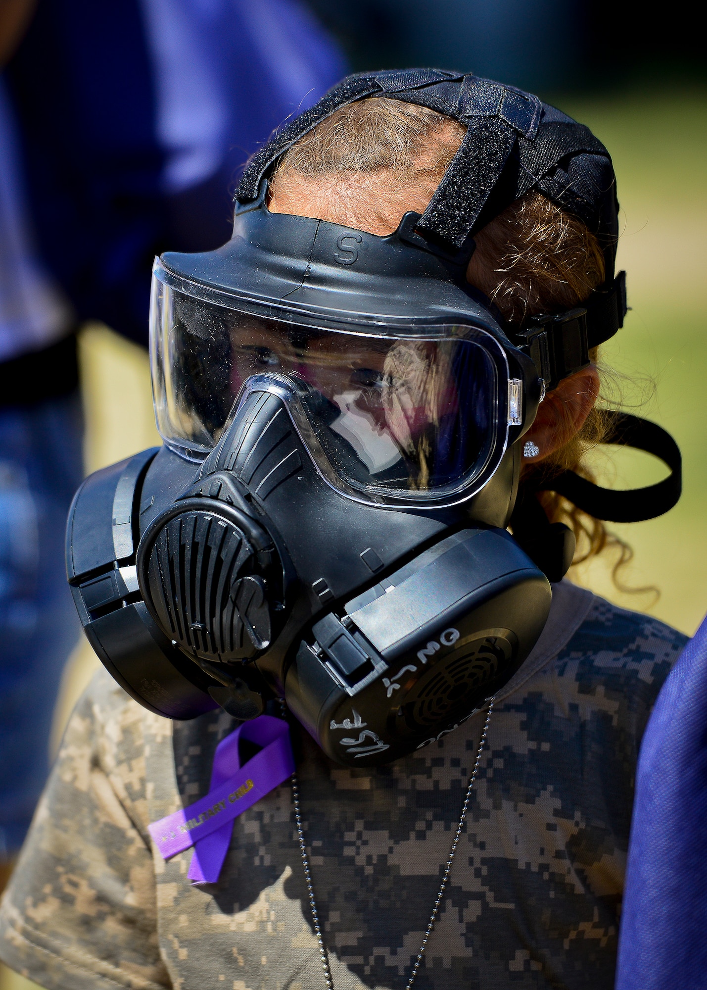 A little deployer tries on an M-50 gas mask during Operation Hero April 12 at Eglin Air Force Base, Fla.  Nearly 400 adults and children participated in the program this year, which served as a way to help children understand the military and the deployment process their parents have or could face.  The kids went through a deployment line to get their uniforms, dog tags and shots before they were briefed by their commander and shipped off to a deployed location.  There, they encountered military demonstrations, equipment and obstacle courses.  (U.S. Air Force photo/Samuel King Jr.)
