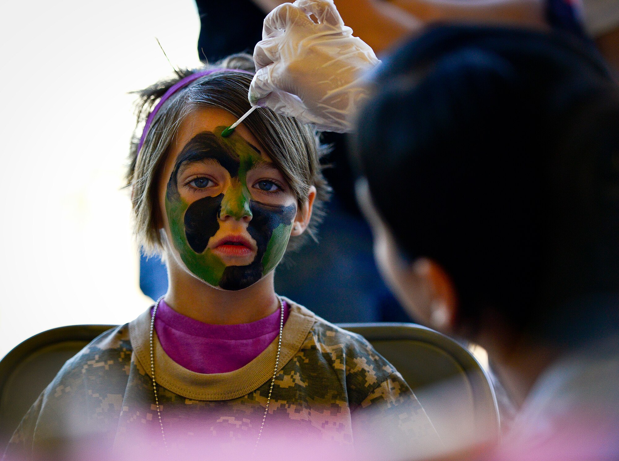 A little deployer prepares for war by getting her face painted during Operation Hero April 12 at Eglin Air Force Base, Fla.  Nearly 400 adults and children participated in the program this year, which served as a way to help children understand the military and the deployment process their parents have or could face.  The kids went through a deployment line to get their uniforms, dog tags and shots before they were briefed by their commander and shipped off to a deployed location.  There, they encountered military demonstrations, equipment and obstacle courses.  (U.S. Air Force photo/Samuel King Jr.)