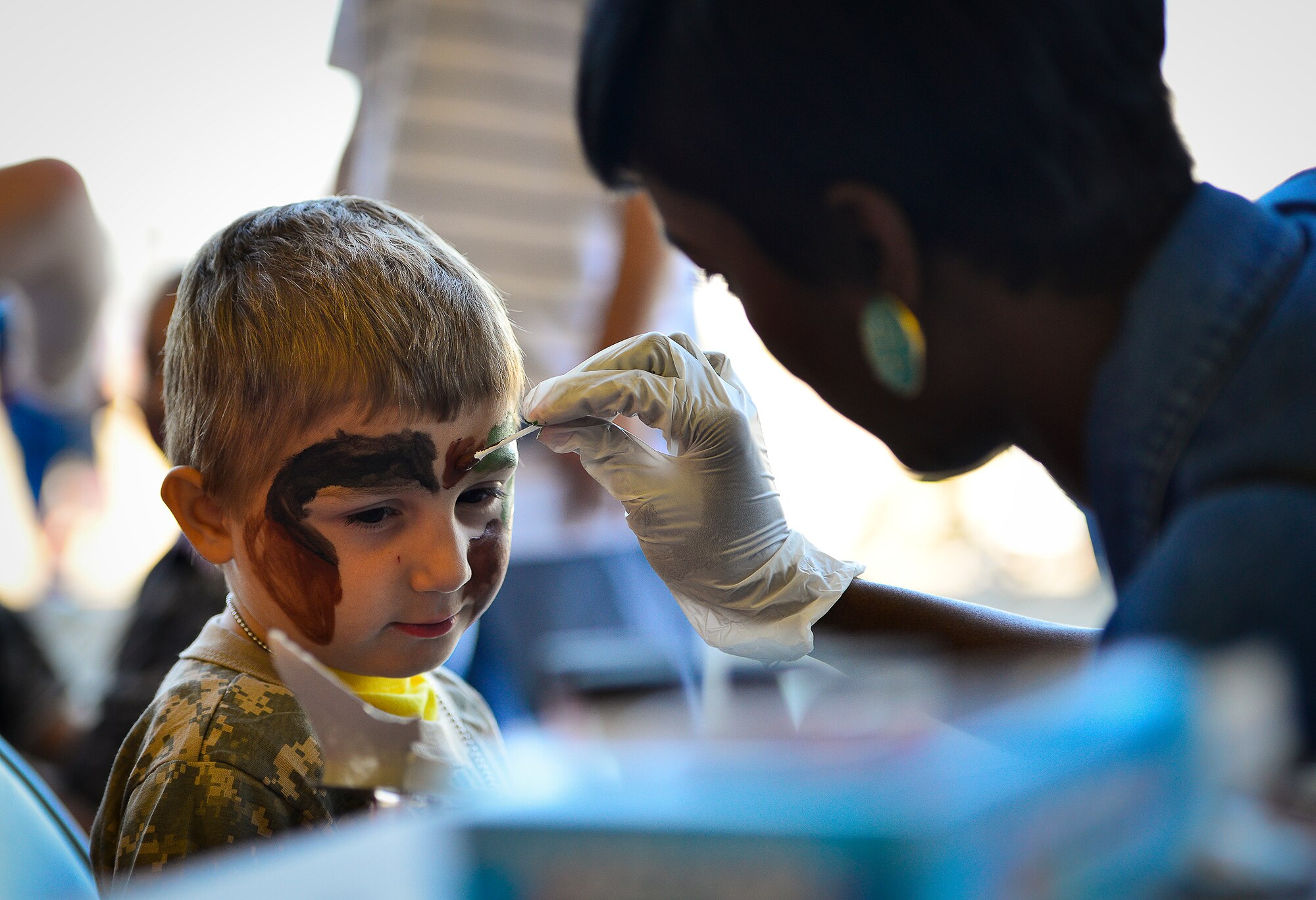A little deployer prepares for war by getting his face painted during Operation Hero April 12 at Eglin Air Force Base, Fla.  Nearly 400 adults and children participated in the program this year, which served as a way to help children understand the military and the deployment process their parents have or could face.  The kids went through a deployment line to get their uniforms, dog tags and shots before they were briefed by their commander and shipped off to a deployed location.  There, they encountered military demonstrations, equipment and obstacle courses.  (U.S. Air Force photo/Samuel King Jr.)