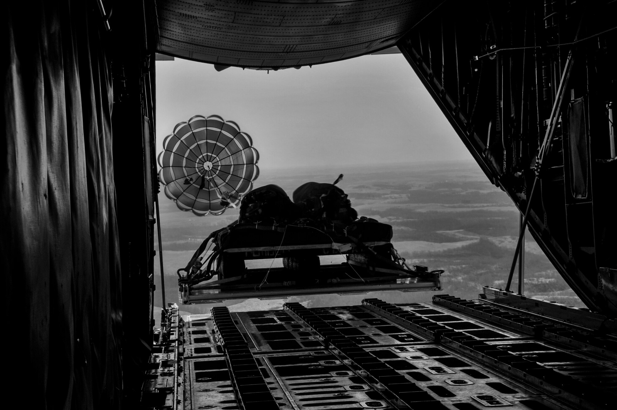 A heavy equipment platform is dropped out of the back of a C-130 Hercules over a designated drop zone in Cadiz, Ohio during a flight generation exercise, April 6, 2014. The exercise, which consisted of crucial combat training for aircrew, simulated dropping supplies and equipment to ground forces within a combat zone. (U.S. Air Force photo by Senior Airman Joshua J. Seybert)