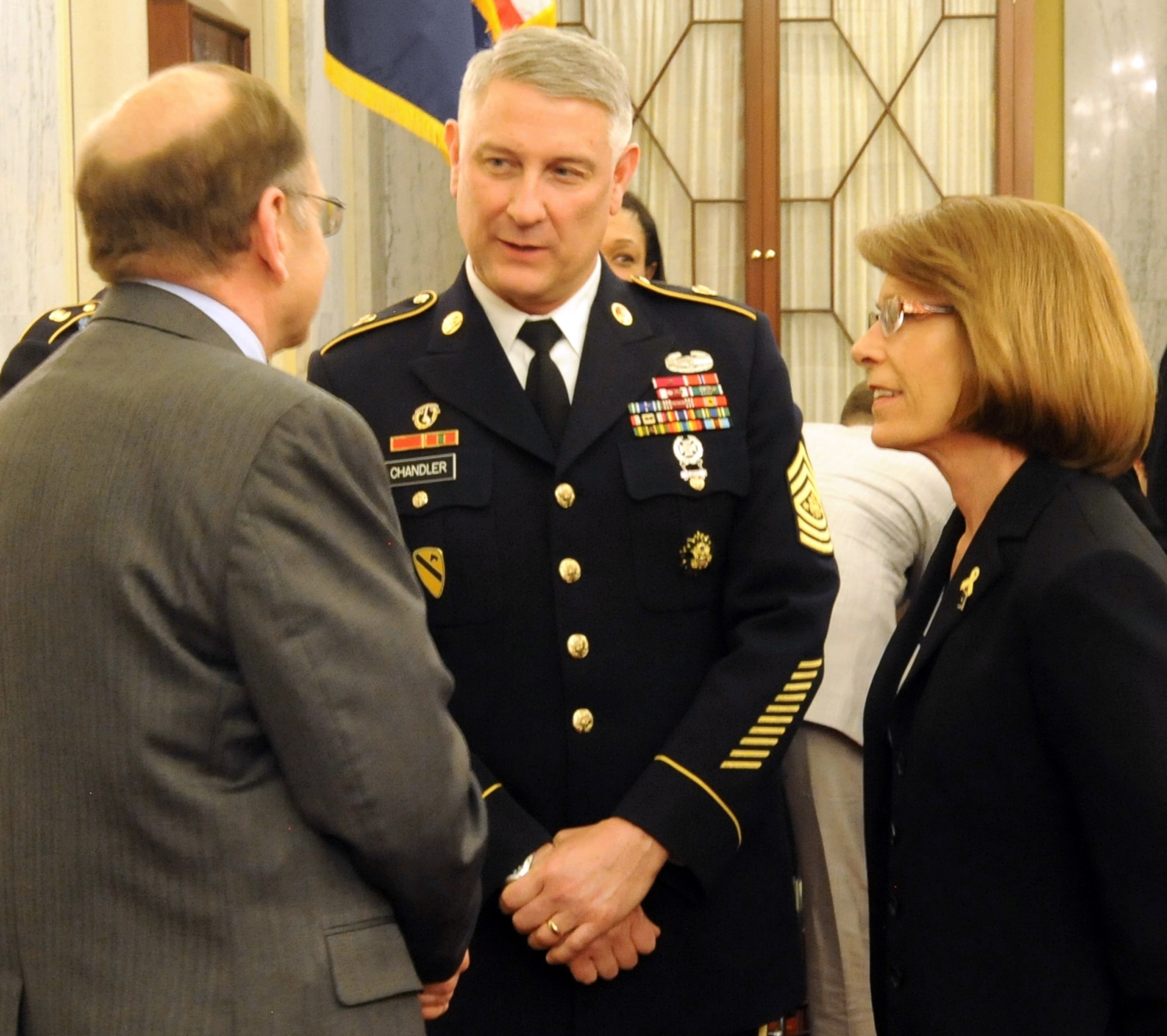 Sgt. Maj. of the Army Ray Chandler (center) and his wife Jeanne speak to Gary Leeling, general counsel for the Senate Armed Services Committee, during a break in the Personnel Subcommittee's hearing on Capitol Hill, April 9, 2014. Chandler and his service counterparts provided testimony related to quality of life issues. (U.S. Army photo by Sgt. Maj. Troy Falardeau/Released)