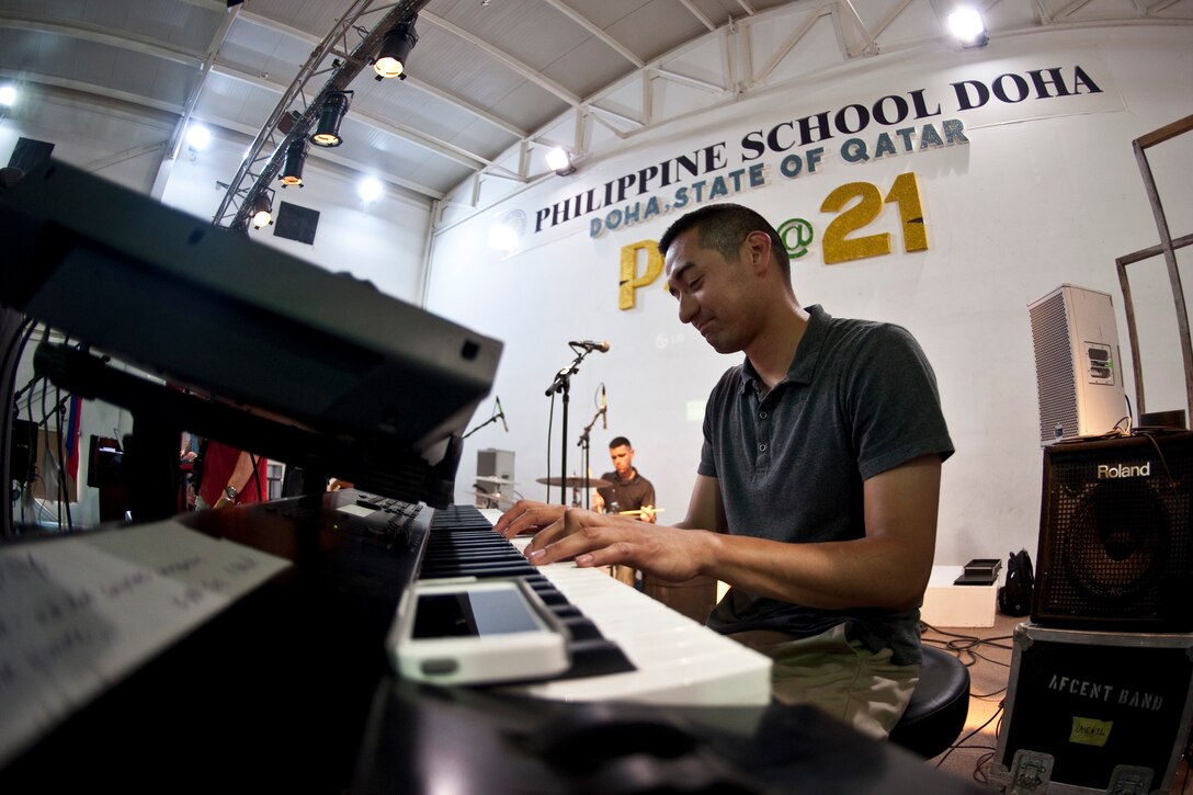 U.S. Air Force Staff Sgt. Dennis Lambert, pianist and music director for U.S. Air Forces Central Command "Hypersonic" band, plays for students and facility members at the Philippine School of Doha, Qatar, March 14, 2014. (U.S. Air Force photo by Senior Airman Michael Ellis/Released)