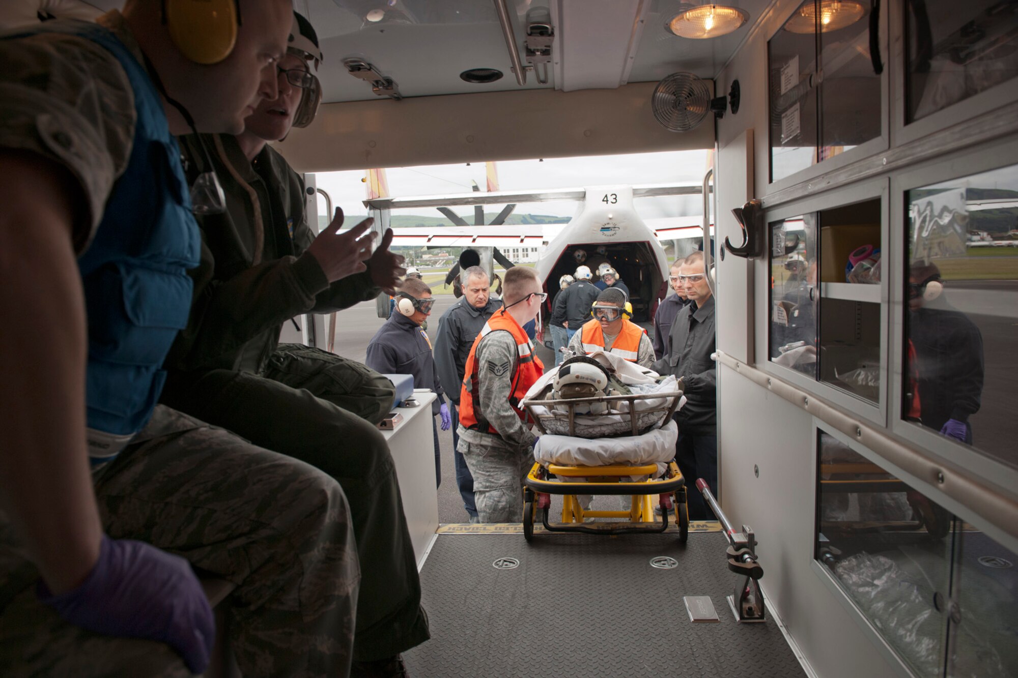 First responders from the 65th Medical Group and a U.S. Navy flight crew place a patient into an ambulance during a medical evacuation mission here, April 11, Lajes Field, Azores.  A U.S. Navy Sailor required medical evacuation to Lajes Field due to acute abdominal pain.  First responders with the 65th Medical Group provided emergent care to the Sailor before the patient was transferred to a local hospital for care.  (U.S. Air Force photo by Tech. Sgt. Paul Villanueva II/Released)