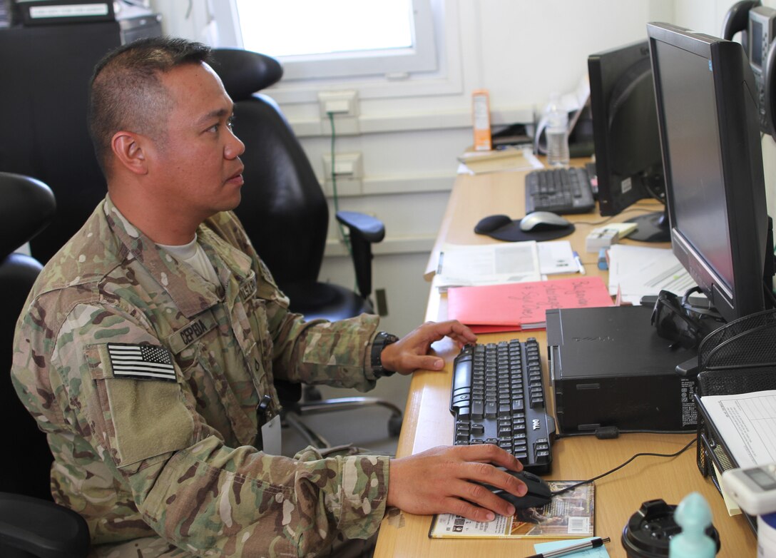 Army Pfc. Clark Cepeda works at his computer at Kandahar Airfield, Afghanistan, April 9, 2014. Cepeda, a training room clerk for 4th Infantry Brigade Combat, 4th Infantry Division, is serving on his first deployment. U.S. Army photo by Sgt. Antony S. Lee