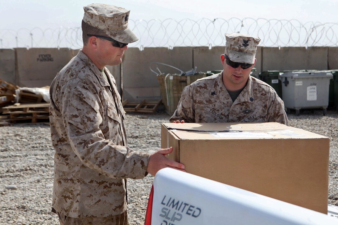 U.S. Navy Lt. j.g. Chad Goddard, left, and U.S. Navy Petty Officer 2nd Class Michael Tadlock unload care packages the San Diego Padres donated to U.S. Marines and sailors assigned to Marine Aerial Refueler Transport Squadron 352 on Camp Bastion in Afghanistan's Helmand province, April 11, 2014. Goddard is a chaplain assigned to Marine Expeditionary Brigade Afghanistan and Tadlock is a religious program specialist.

