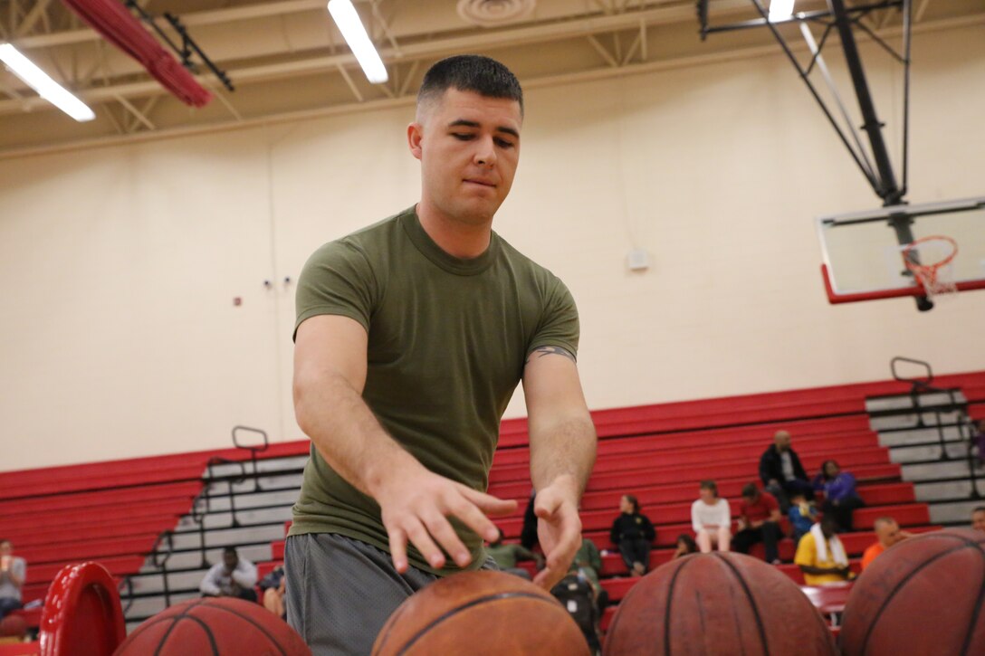 Tyler Szarenski, a player for the Marine Corps University Intramural Basketball Team, reaches for a ball during a 3-point shot challenge before the intramural All-Star Basketball Game on April 7, 2014, at the Barber Physical Activity Center. Szarenski won the challenge by one point with a final score of 17 points.