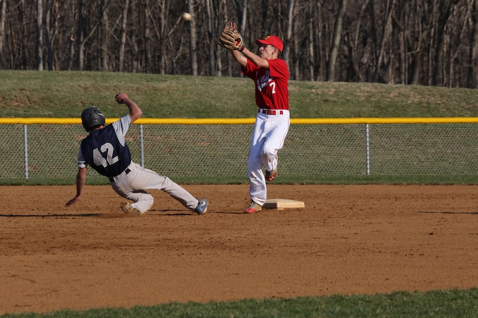Treyton, a shortstop for the Quantico Middle/High School Warrior Baseball Team, jumps for a ball thrown by the catcher in an attempt to throw out a player at second base from the Holy Family Academy from Manassas, during a game at George Hellwig Memorial Park in Manassas on April 9, 2014. Treyton pitched the first five innings of the game throwing nine strikeouts and allowing five walks then moved to shortstop. 