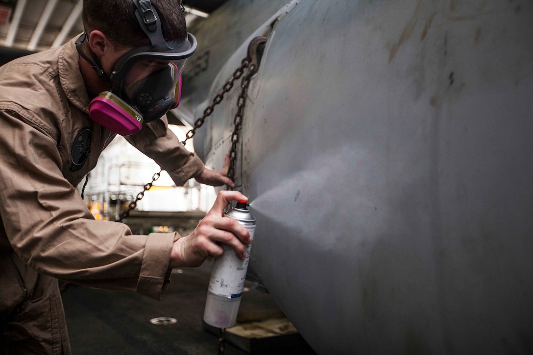 U.S. Marine Corps Sgt. Tyler Deckard, Marine Medium Tiltrotor Squadron (VMM) 263 (Reinforced), 22nd Marine Expeditionary Unit (MEU), corrosion control noncommissioned officer in charge and native of Bartlesville, Okla., touches up some chips and scratches in the paint of an MV-22 Osprey aircraft to protect the aircraft from corrosion aboard the USS Bataan (LHD 5). Many of the aircraft’s markings were hand painted or custom created by Deckard and other MEU Marines, including the squadron’s logo on the tail of the Ospreys. The MEU is deployed to the U.S. 5th Fleet area of operations with the Bataan Amphibious Ready Group as a sea-based, expeditionary crisis response force capable of conducting amphibious missions across the full range of military operations.