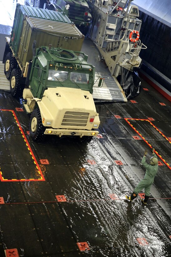 Marines with the 11th Marine Expeditionary Unit back a 7-ton truck onto a landing craft air cushion aboard the USS Makin Island during Amphibious Squadron Marine Expeditionary Unit Integration Training (PMINT) off the coast of San Diego, April 11. The 11th MEU, partnered with the Makin Island Amphibious Ready Group, is conducting PMINT in preparation for an upcoming deployment. (U.S. Marine Corps photo by Sgt. Melissa Wenger/Released)