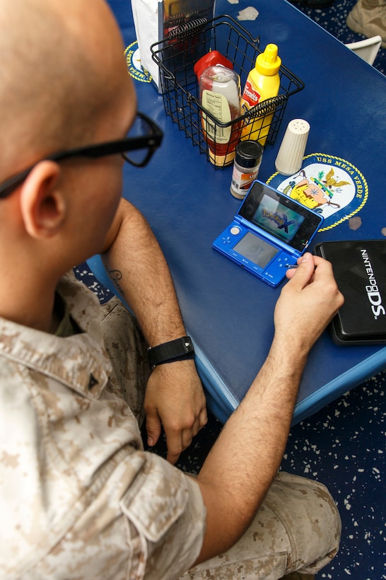 U.S. Marine Corps Lance Cpl. Dominique Jamatte, Combat Logistics Battalion 22, 22nd Marine Expeditionary Unit (MEU), operations clerk and native of Wilmington, Del., prepares his Nintendo 3DS for a Pokémon tournament held aboard the USS Mesa Verde (LPD 19) during a morale, welfare and recreation event called ‘nerd night.’ The 22nd MEU is deployed with the Bataan Amphibious Ready Group as a theater reserve and crisis response force throughout U.S. Central Command and the U.S. 5th Fleet area of responsibility.