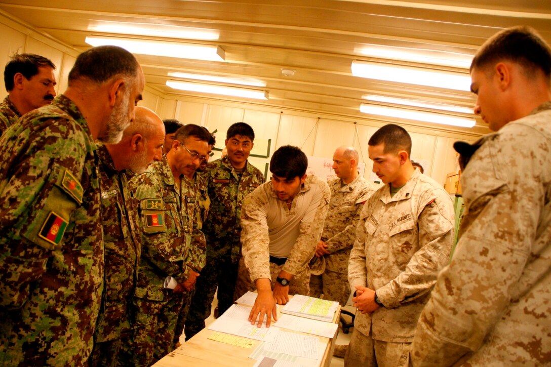 Corporals Christopher Mosqueda, right-center, and Jonathan Arroyo, right, telecommunication technicians, Combat Logistics Battalion 7, discuss the proper paperwork process for submitting maintenance claims for equipment needing repairs with Afghan National Army soldiers from the 215th Corps aboard Camp Leatherneck, Helmand province, Afghanistan, April 6, 2014. The period of instruction was part of the curriculum review for the upcoming Communication Electronics Maintenance Course scheduled to begin this month.