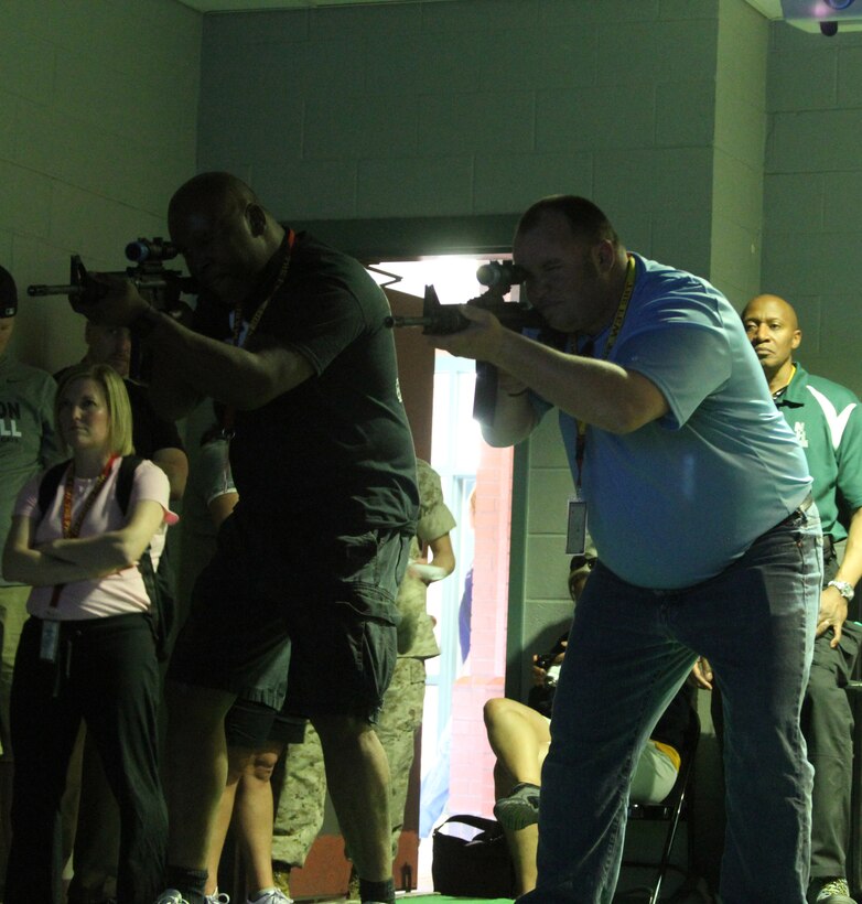 Victor Holman, right, an English teacher at Franklin High School in Canton, Mich., and Jamison Grime, left, an educator with Montpelier High School in Montpelier, Ohio, practice shooting M4 carbines in the indoor simulated marksmanship trainer during Recruiting Station Detroit’s Educator Workshop at Marine Corps Recruit Depot Parris Island, S.C. April 3, 2014. The Educator Workshop is an annual program conducted by recruiting stations across the United States with the goal of enhancing educator’s knowledge about the Marine Corps for when they advise their students about possible career paths. (U.S. Marine Corps photo by Cpl. Tyler Birky/Released)