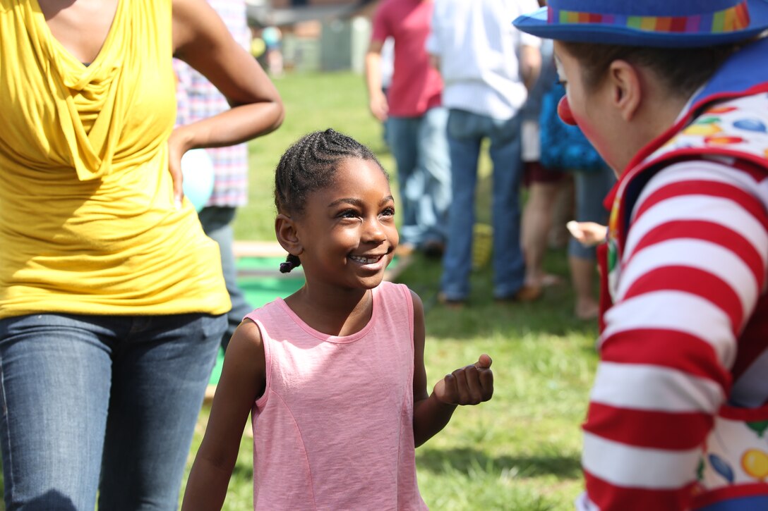 Makaila, 6, talks to C.C. the Clown about her missing tooth during the Kids First Fair at the Religious and Family Services field on April 12, 2014. C.C. the Clown made balloon figures for the children who were participating.
