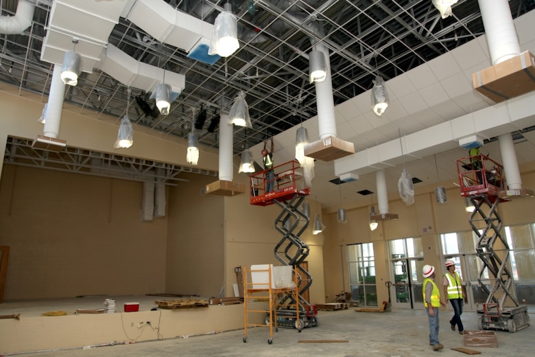 Workers apply ceiling tiles inside a dual-space cafeteria and auditorium (called a "cafetorium") at the new Murray Elementary School. The room includes a built in stage. 