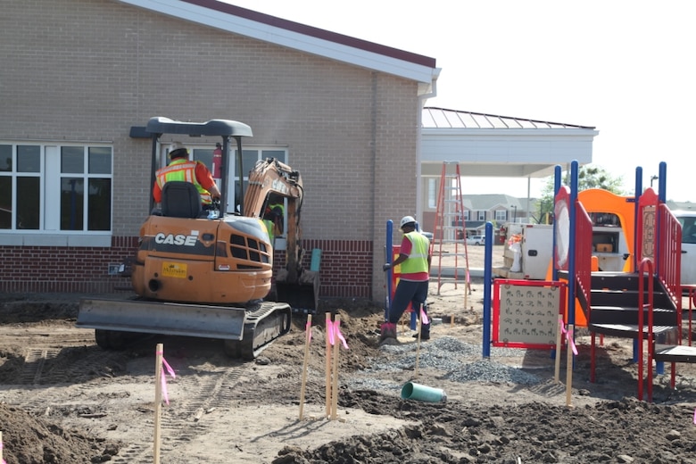 Workers prepare the ground for paving and landscaping surrounding a playground at the new Murray Elementary School. The school includes multiple playgrounds designed for children grades K-6. 