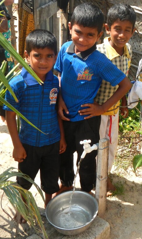 A few boys stand next to one of the new water spigots in Puttalam, Sri Lanka. The U.S. Army Corps of Engineers Alaska District, U.S. Pacific Command and the U.S. Agency for International Aid are coordinating an effort to connect 371 family households to the town's water supply.