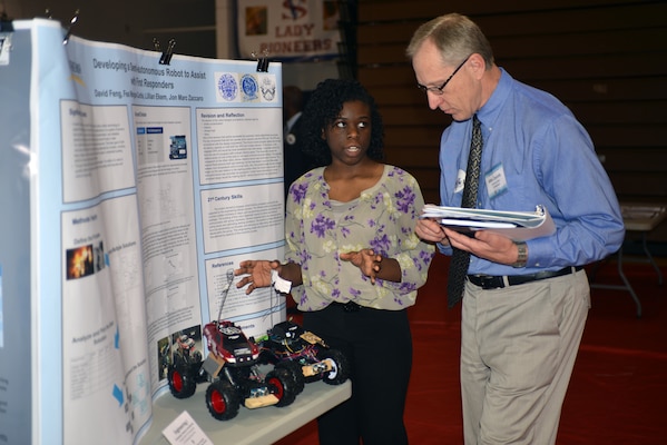 Lillian Ekem, a student from Martin Luther King high school in Nashville, explains the functions of a remote–controlled bot to Michael Zoccola, chief, geotechnical Branch at a STEM Expo sponsored by the Middle Tennessee STEM Innovation Hub at the Volunteer State Community College in Gallatin on April 11, 2014.  The bot car was developed to assist with Emergency First Responders and collect data in Combating House Fires.  Zoccola and a group of technical experts from the U.S. Army Corps of Engineers Nashville District attended the Science, Technology, Engineering and Mathematics Science Expo and judged the event.   