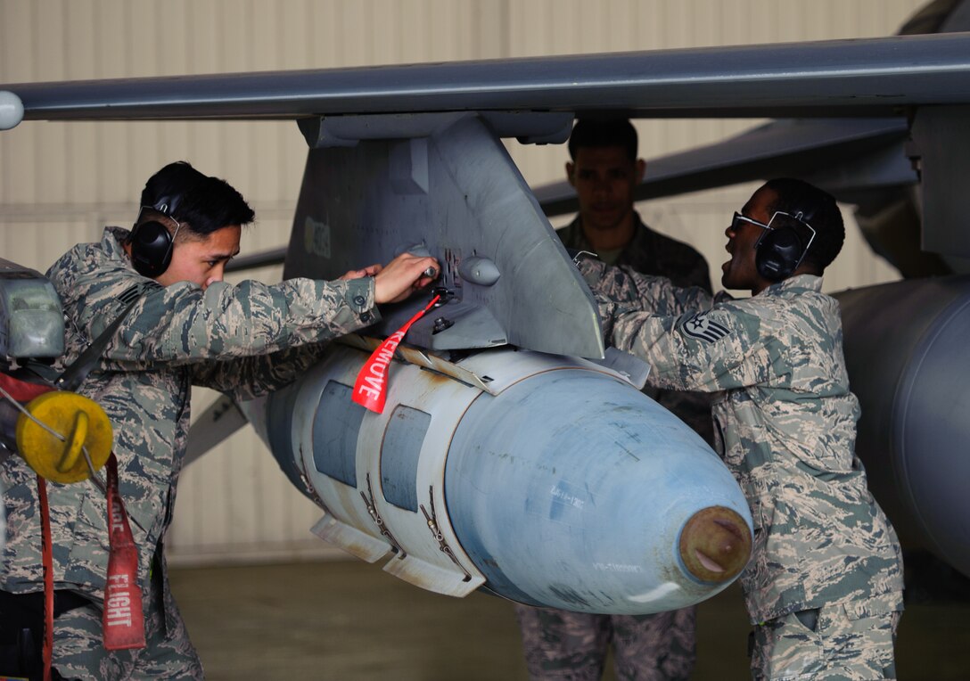 Staff Sgt. Trumaine Cox, 80th Aircraft Maintenance Unit weapons load crew member, right, and Senior Airman Ryanted Duarte, 80th AMU load crew member, left, load a guided bomb unit during the 1st Quarter Load Competition at Kunsan Air Base, Republic of Korea, Apr. 11, 2014. The 8th Maintenance Group weapons standardization team hosted the competition to showcase the skills and abilities of each AMU squadron as well as to promote espirit de corps. (U.S. Air Force photo by Senior Airman Armando A. Schwier-Morales/Released)