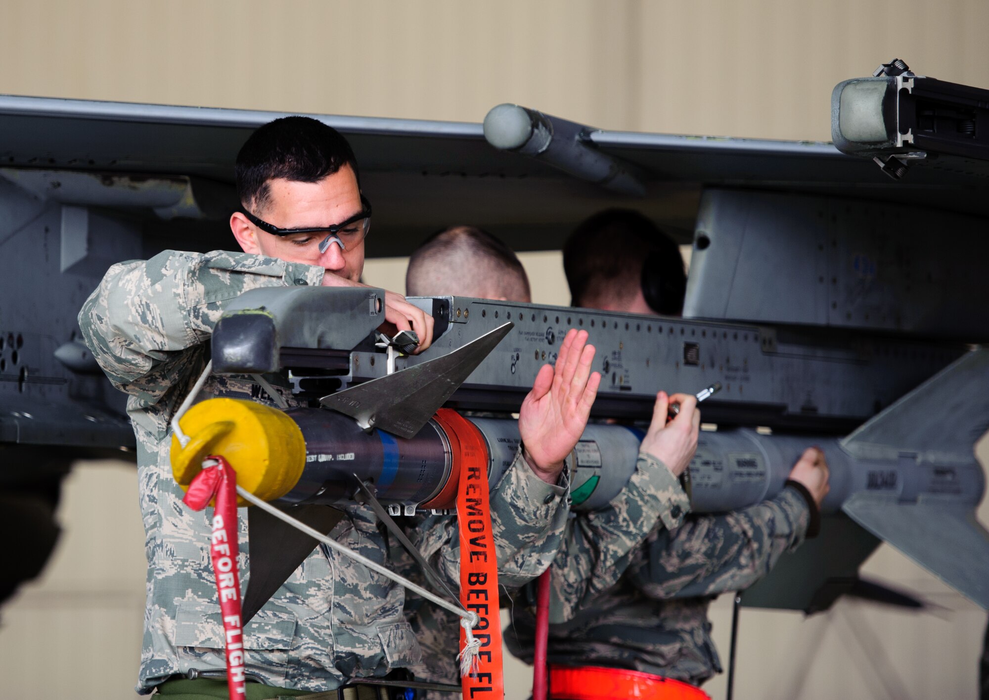 Senior Airman Christopher Webb, 35th Aircraft Maintenance Unit weapons load crew member, left, and his team, load a missile during the 1st Quarter Loading Competition at Kunsan Air Base, Republic of Korea, Apr. 11, 2014. The 8th Maintenance Group weapons standardization team hosted the competition to showcase the skills and abilities of each AMU squadron as well as to promote espirit de corps. (U.S. Air Force photo by Senior Airman Armando A. Schwier-Morales/Released) 