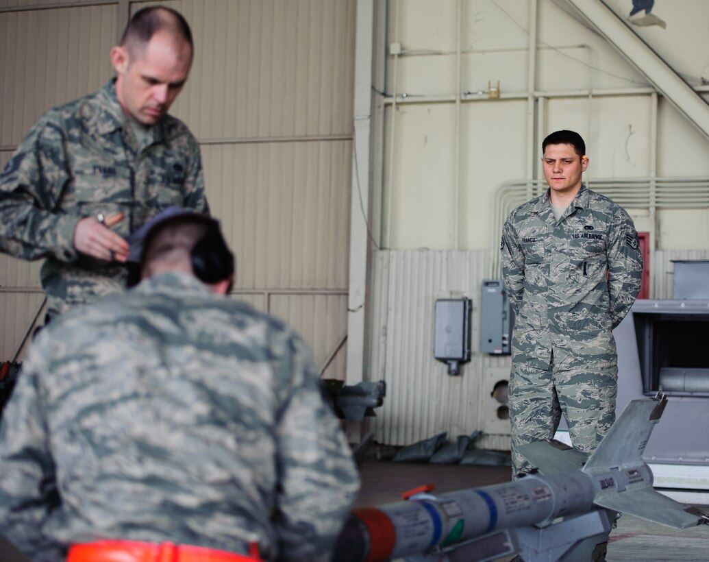 Staff Sgt. Vincent Franco, 8th Maintenance Group weapons standardization section inspector, right, inspects Staff Sgt. Adam Evens, 35th Aircraft Maintenance Unit weapons load crew member, and the 35th AMU team during the 1st Quarter Loading Competition at Kunsan Air Base, Republic of Korea, Apr. 11, 2014. The 8th MXG WSS hosted the competition to showcase the skills and abilities of each AMU squadron as well as to promote espirit de corps. (U.S. Air Force photo by Senior Airman Armando A. Schwier-Morales/Released)