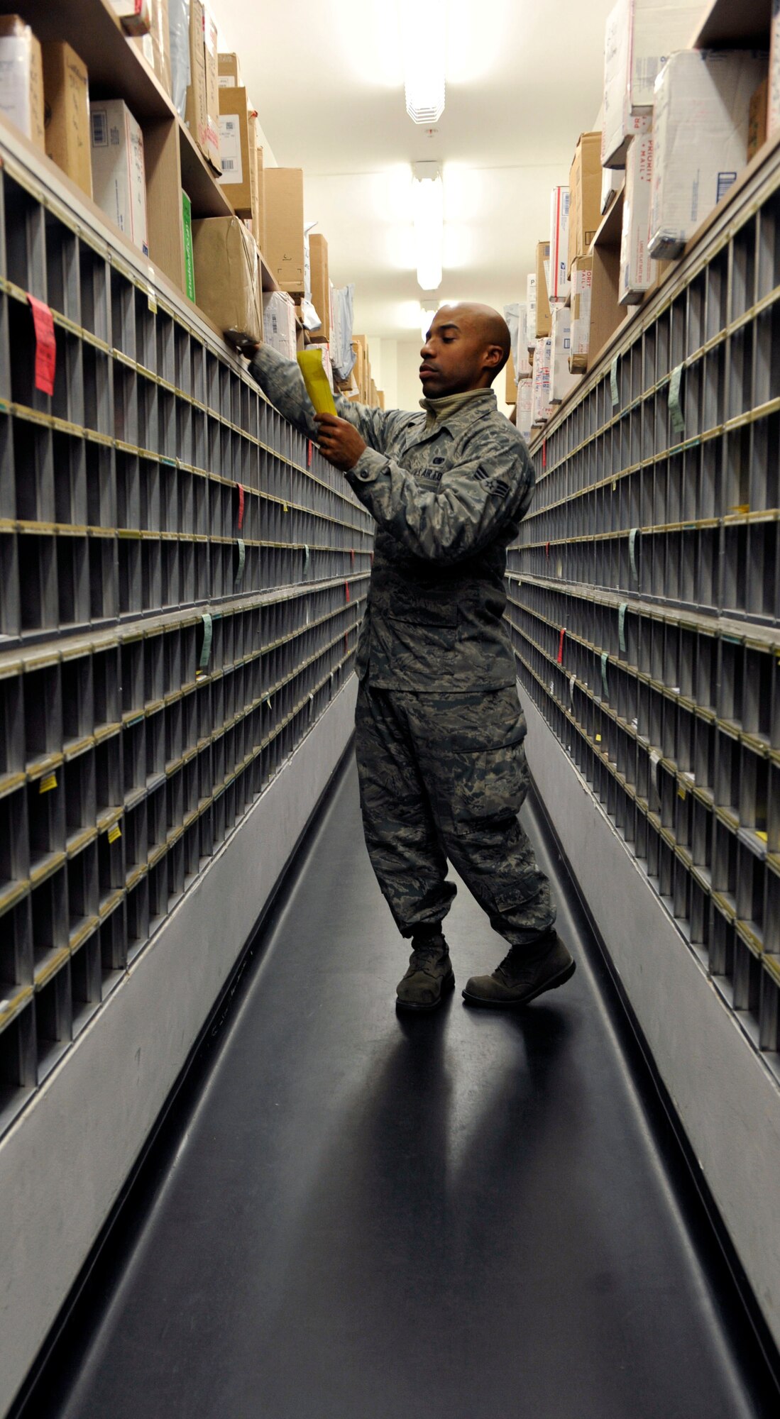 Senior Airman Ricardo Wilson, a 51st Communication Squadron postal specialist, grabs a package in the mail box aisle for a service member April 10, 2014 at the post office at Osan Air Base, Republic of Korea. The post office received an outstanding in each of the four sections during the inspection. (U.S. Air Force photo by Senior Airman David Owsianka)