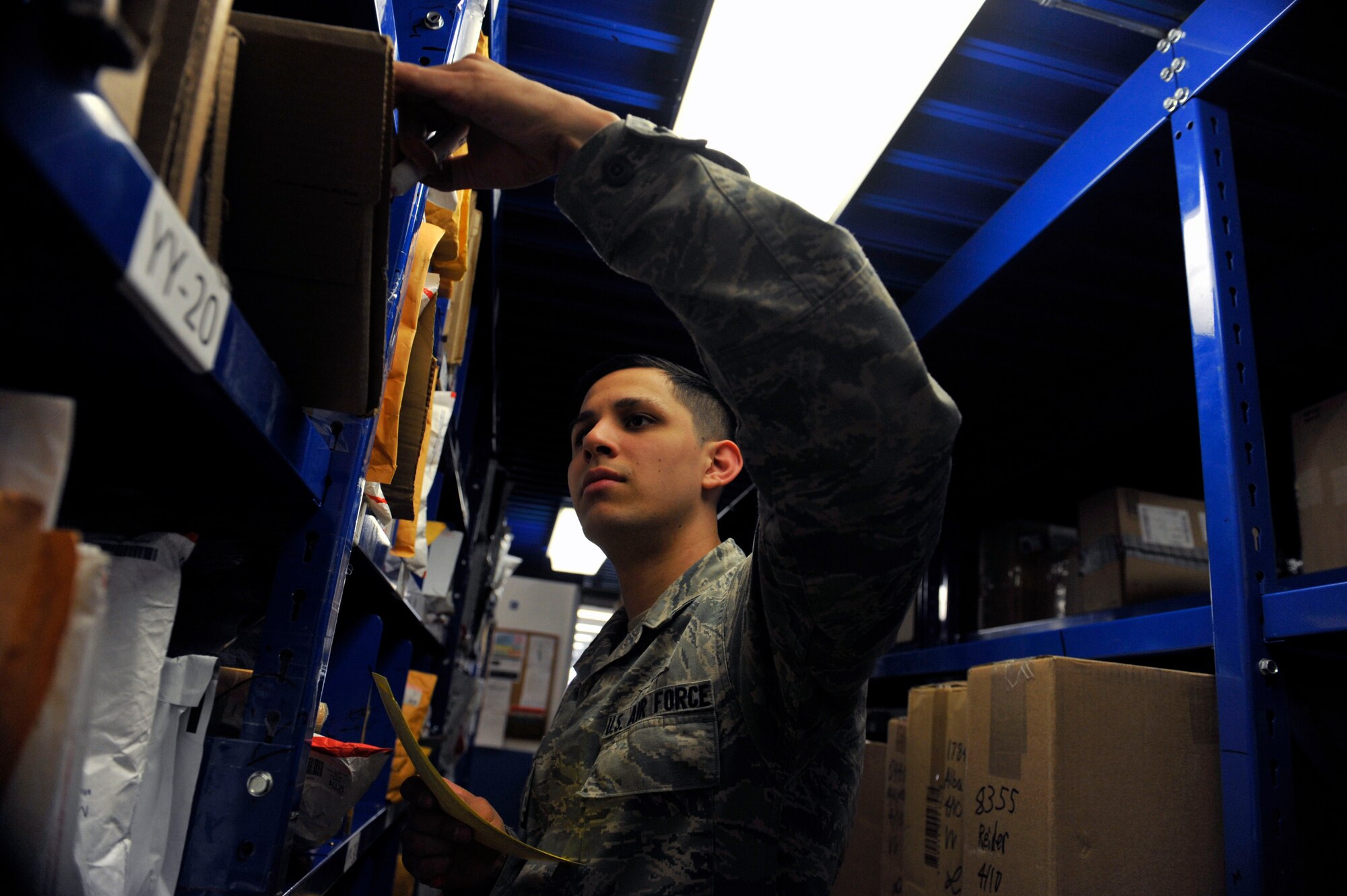 Senior Airman Devin Quintanilla, a 51st Communication Squadron postal clerk, writes a hold notice on a package April 10, 2014 at the post office at Osan Air Base, Republic of Korea. The postal service center receives approximately 800-1000 packages per day. (U.S. Air Force photo by Senior Airman David Owsianka)
