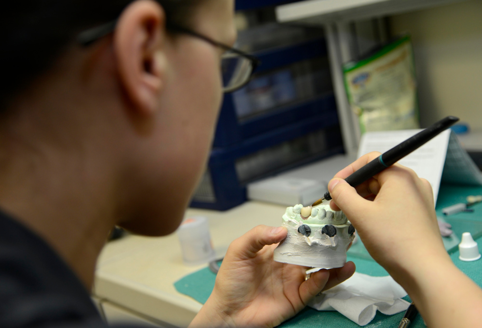 Air Force Staff Sgt. Katlyn Dumancas, 673d Dental Squadron dental lab technician, applies custom layered stacked ceramic art porcelain restorations at Joint Base Elmendorf-Richardson, Alaska, April 8, 2014. The restoration offers patients conservative an esthetic treatment when replacing a single unit crown. (U.S. Air Force photo/Staff Sgt. Sheila deVera)