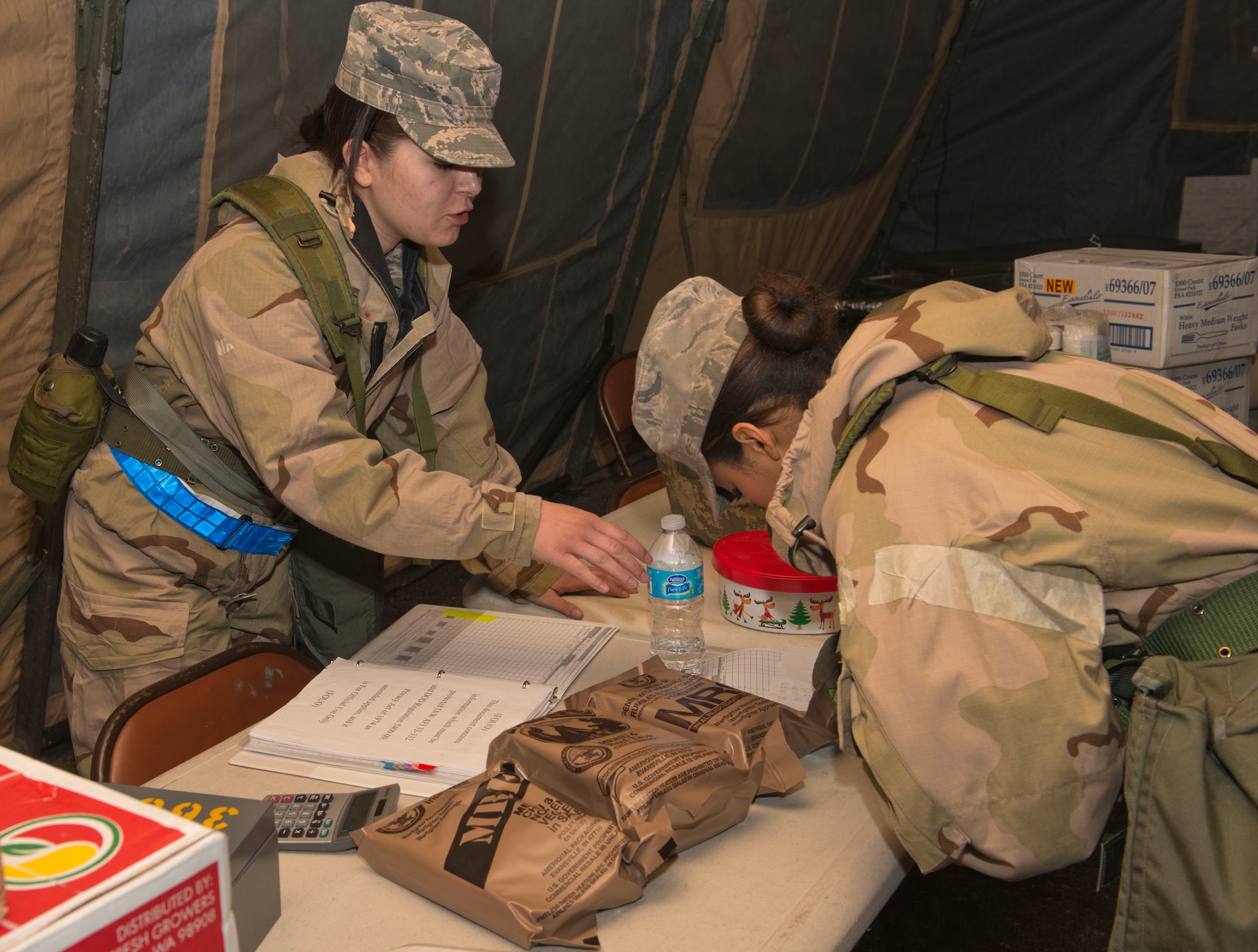 Airman 1st Class Kristina Hampton, 366th Force Support Squadron food services apprentice, sells prepackaged food known as Meals Ready to Eat, or MREs, to Airman Andrea Dunphy, 366th Force Support Squadron food services apprentice, during the Sharpshooter 14-02 exercise April 15, 2014, Mountain Home Air Force Base, Idaho. During the duration of the exercise, Airmen have the opportunity to purchase MRE’s. (U.S. Air Force photo by Airman 1st Class Malissa Lott) 