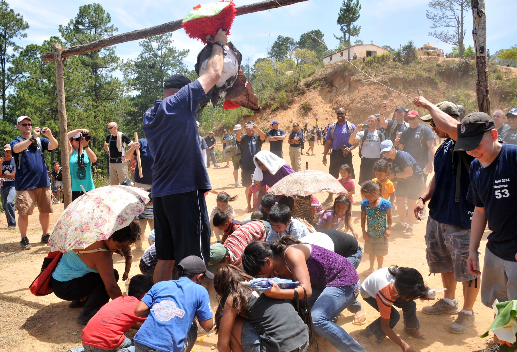 Children from the village of Picacho, Honduras scramble to gather candy from a pinata.  More than 130 members of Joint Task Force-Bravo completed a 6.2 mile round trip hike to deliver more than 3,000 pounds of food and supplies to families in need in the mountain village, April 12, 2014. During the more than three mile trek up the mountain, Task Force members made an elevation gain of 1,600 feet while carrying more than 25 pounds of supplies each. The food and supplies were all purchased with donations made by the members of Joint Task Force-Bravo. (Photo by Ana Fonseca)