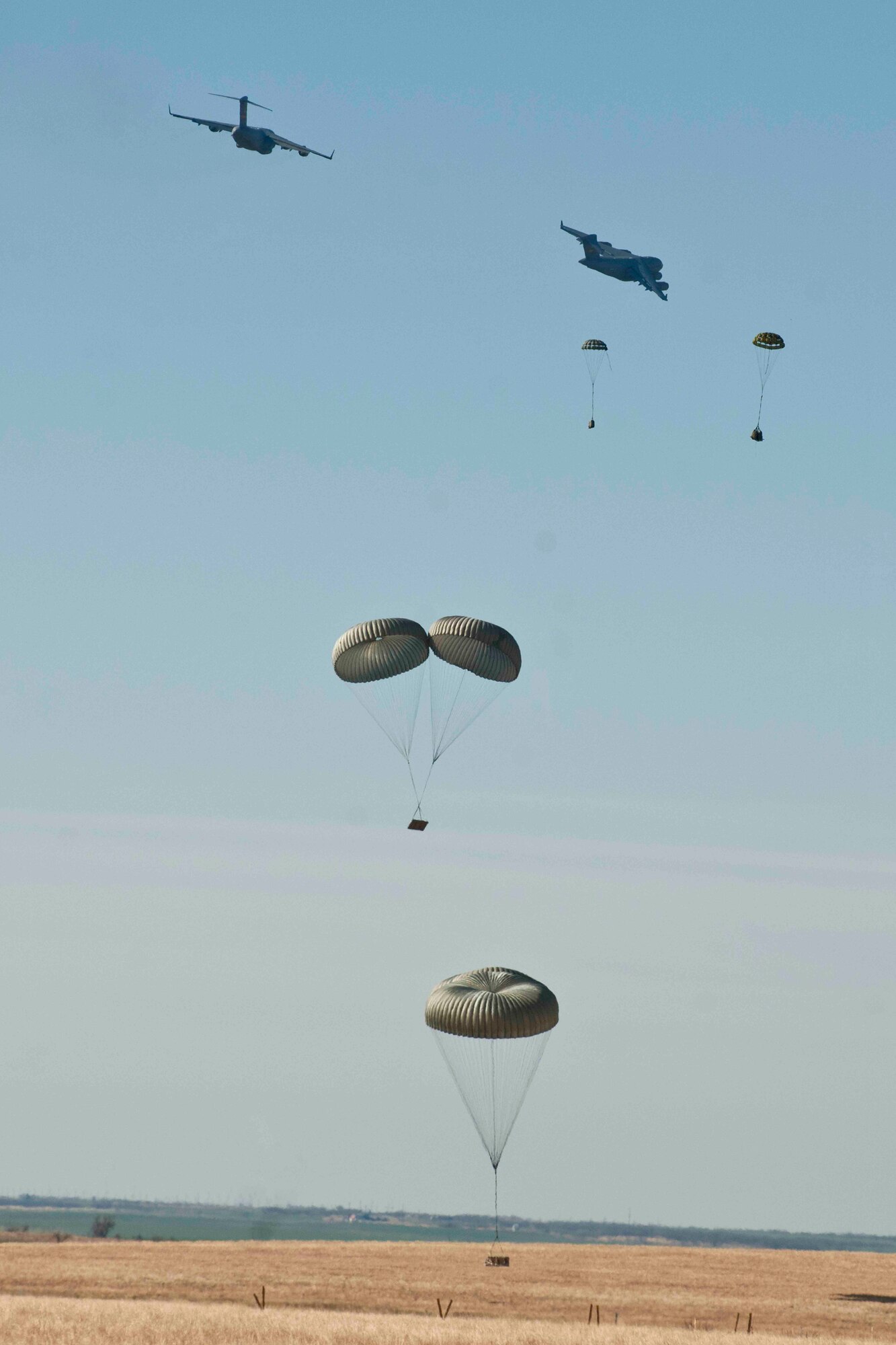 HOLLIS, Okla. – Members of the 58th Airlift Squadron use the container delivery system to release training cargo out of a U.S. Air Force C-17 Globemaster III during an airdrop training mission at the Sooner Drop Zone April 11, 2014. The 97th Aerial Operations Flight prepared airdrop cargo pallets and loaded them onto the C-17. Their mission provides C-17 aircrews with realistic training scenarios, which consist of on and off loading general cargo and vehicles as well as aerial delivery materials for airdrop training. (U.S. Air Force photo by Senior Airman Jesse Lopez/Released) 