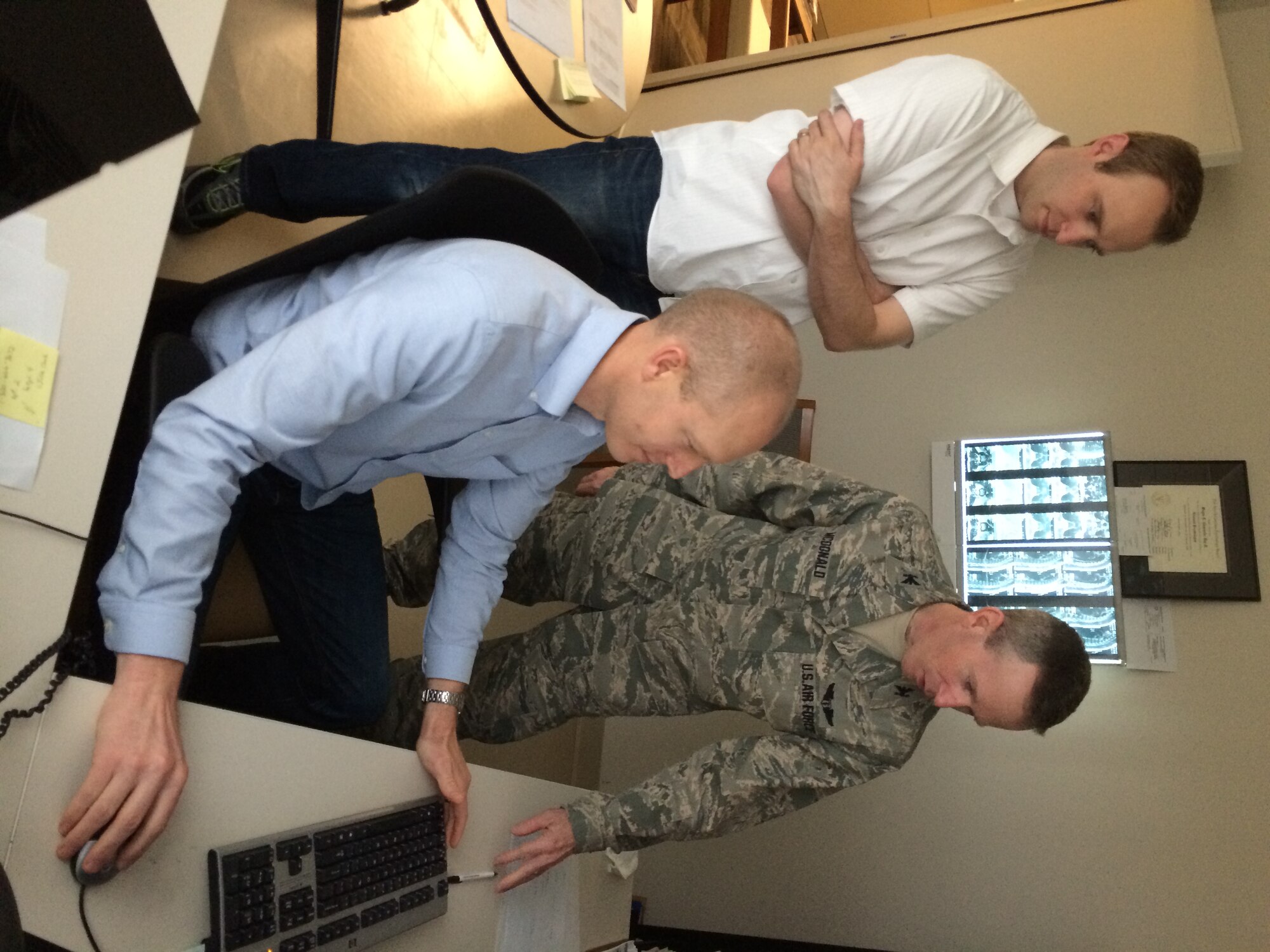 Col. (Dr.) Kent McDonald (standing right) confers with Dr. Wayne Chappelle, senior aeromedical clinical psychologist, Aerospace Medicine Consultation Division, U.S. Air Force School of Aerospace Medicine (sitting), and John Heaton, Neuropsychiatry branch manager, USAFSAM.