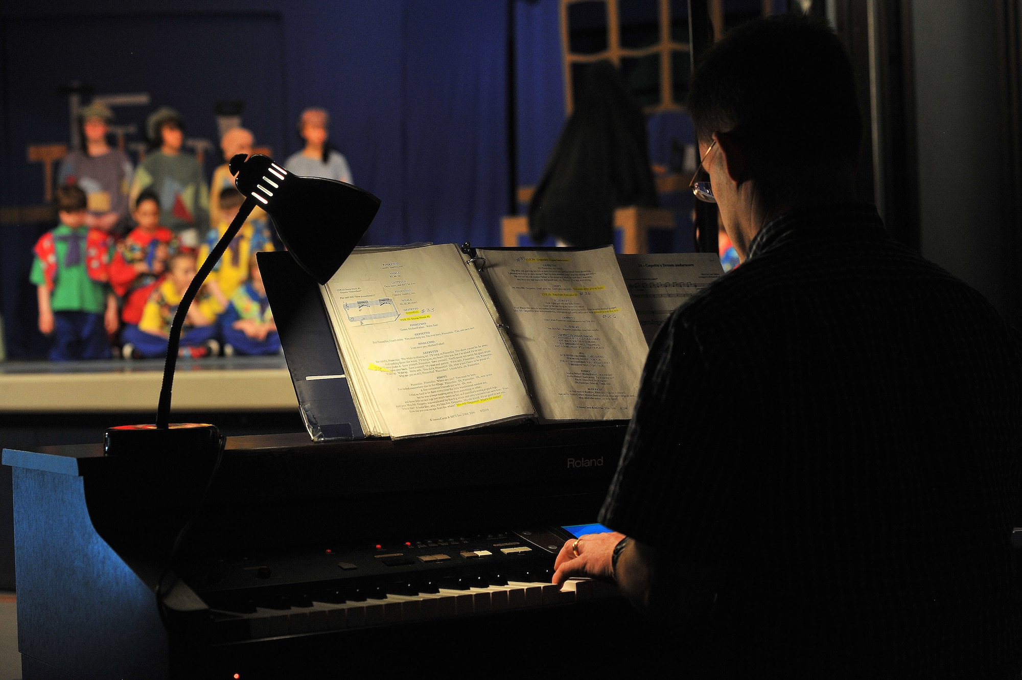 Craig Johnson, Child and Youth program assistant, plays the piano during the “Pinocchio” performance from the Missoula Children’s Theater and Fairchild youth April 11, 2014, at Michael Andersen Elementary School. Forty two children from ages 5 to 16 were part of this year’s production. (U.S. Air Force photo by Staff Sgt. Veronica Montes/Released)